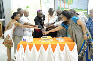 Archbishop Kivuva of Mombasa leads Diocesan Communications Team in Cutting the Cake during the launch of the film Chozi 