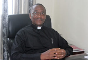 Fr. Fredrick takes over in his new office at the Uganda Catholic Secretariat