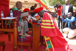 Honoured. Gulu University Chancellor Prof Frederick Kayanja confers Honorary Doctorate of Philosophy on Archbishop Odama during the university’s 12th graduation ceremony last Saturday.