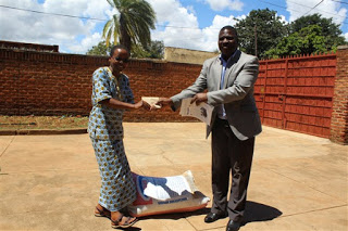 Catholic Secretariat's Director of Finance and Administration handing over cash to Sister Massawe as contributed by Catholic Secretariat's staff