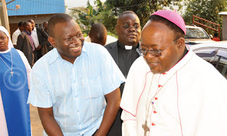 Archbishop Lwanga (R) shares a light moment with Fr. Kibuuka (in a blue shirt) before his was excommunicated
