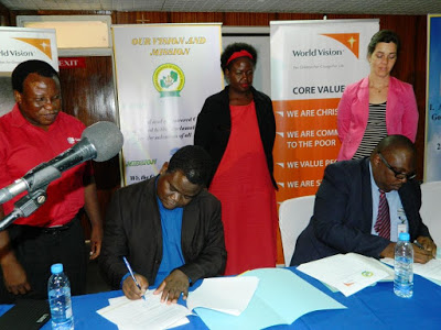 ZCCB Secretary General Fr. Cleophas Lungu (Seated Left) and World Vision Zambia Country Director Mark Kelly (Seated Right) Signing the MoU at ZCCB Kapingila House in Lusaka