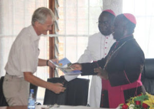Archbishop Msusa Present a copy of the framework to one of the donor partner,Dan Church Aid
