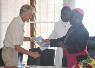 Archbishop Msusa Present a copy of the Strategic Framework to one of the donor partner, Dan from Church Aid