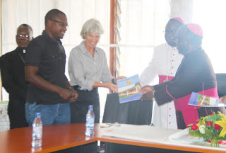 Archbishop Msusa presents a copy to CRS Catholic Director and Trocaire representative