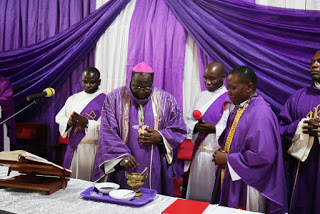 Archbishop Obbo blesses the ashes before administering on faithful. Looking on (R) is the Chaplain of the Uganda Parliamentary Chaplaincy, Rev. Fr. Philip Balikudembe