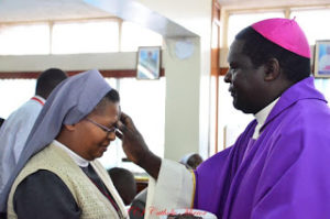 Rt. Rev. Joseph Obanyi administers Ash to an employee of KCCB