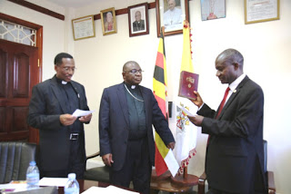 The New UNCCLA president, Ndyanabo (right) takes oath of office. Looking on  is  the Bishop Chairman of Lay Apostolate Commission of the Uganda Episcopal Conference (UEC), Rt. Rev Paul Ssemogerere, also Bishop of Kasana-Luweero Diocese and  Rev. Fr. Fred Tusingire, the UEC-National Executive Secretary of Lay Apostolate