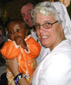 The Late Sr. Patricia holding a baby in one