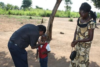 Fr. Arasu blessing the son of Margaret Atem at Bidibidi camp