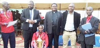 Fr. Kimu and other officials pose with the winning choir