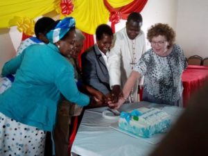 Bishop Alfred Rotich participates in cutting of the cake to mark the official opening of the Loreto Abundant Life Centre, Isinya.