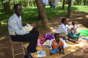 Erick Omondi Otieno holds Baby Samantha as Emma bathes Natalie