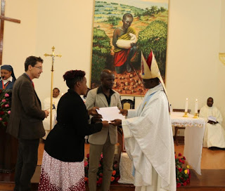 Bishop Muhatia issuing a certificate to couples  who participated in the program