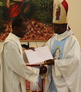 Rev. Fr. Saviour Saka, a Participant from  Archdiocese of Nairobi receiving his  certificate from Bishop Muhatia