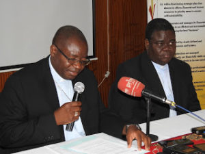 Bishop Chinyemba (holding Mic) addressing the media, not in picture , franked by ZCCB Secretary General Fr. Cleophas Lungu
