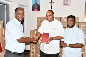 Deputy Secretary General of Tanzania Episcopal Conference (TEC) Rev. Fr. Daniel Dulle (middle) receiving a copy of Swahili Version of Code of Canon Law from Secretary of the TEC Can