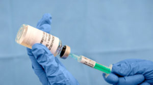 Infectious doctor fills injection syringe with CO-VID 19 vaccine - concept,  for prevention, immunization and treatment  for new corona virus infection(COVID-19,novel coronavirus disease 2019)