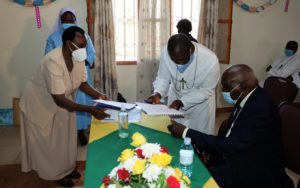 L-R President ARU, Sr. Anamaria Nankusu (fore ground) and Sr. Lydia Apili signing the relevant documents with Prof. John Ssebuufu and Br. Celestine Kakooza Representing UniK