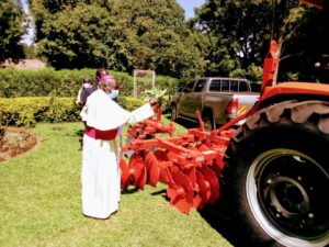 Most Rev John Baptist Odama blessing a new Tractor donated to Acholibur farmers group