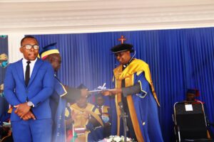 the Chancellor hand over the strategic plan booklet to the Vice-Chancellor.