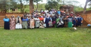 L-R Participants and Facilitators in a group photo during parenting skills training in Jinja-Uganda, Case manager-Caroline Nansukusa making a presentation during the training at Jinja