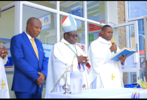 Bishop Kibira in The Middle with Hon. Kabyanga on Left And Fr Byaruhanga During The Blessing Of The Building