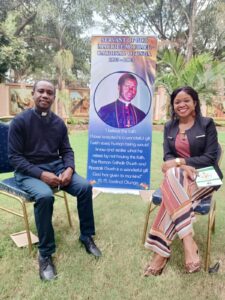 Central Committee Chairman for the Cause of Sainthood, Fr. Peter Kaigua poses for a Post-Interview photo with Multimedia Journalist, Elizabeth Asasha