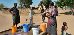 Women drawing water from one of the rehabilitated boreholes by CADECOM