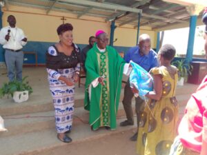 Bishop Nyirenda hand over a bag of maize flour to a woman