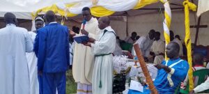 Fr Constanz Opiyo examining the couple at St Peter's Anai