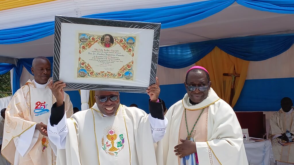 BISHOP KIBIRA WITH FR AUGUSTINE CARRYING THE POPE'S BLESSING